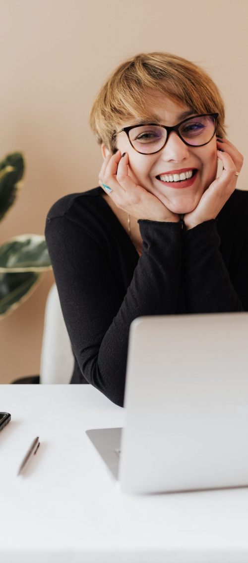 Chica sonriendo frente a laptop - A